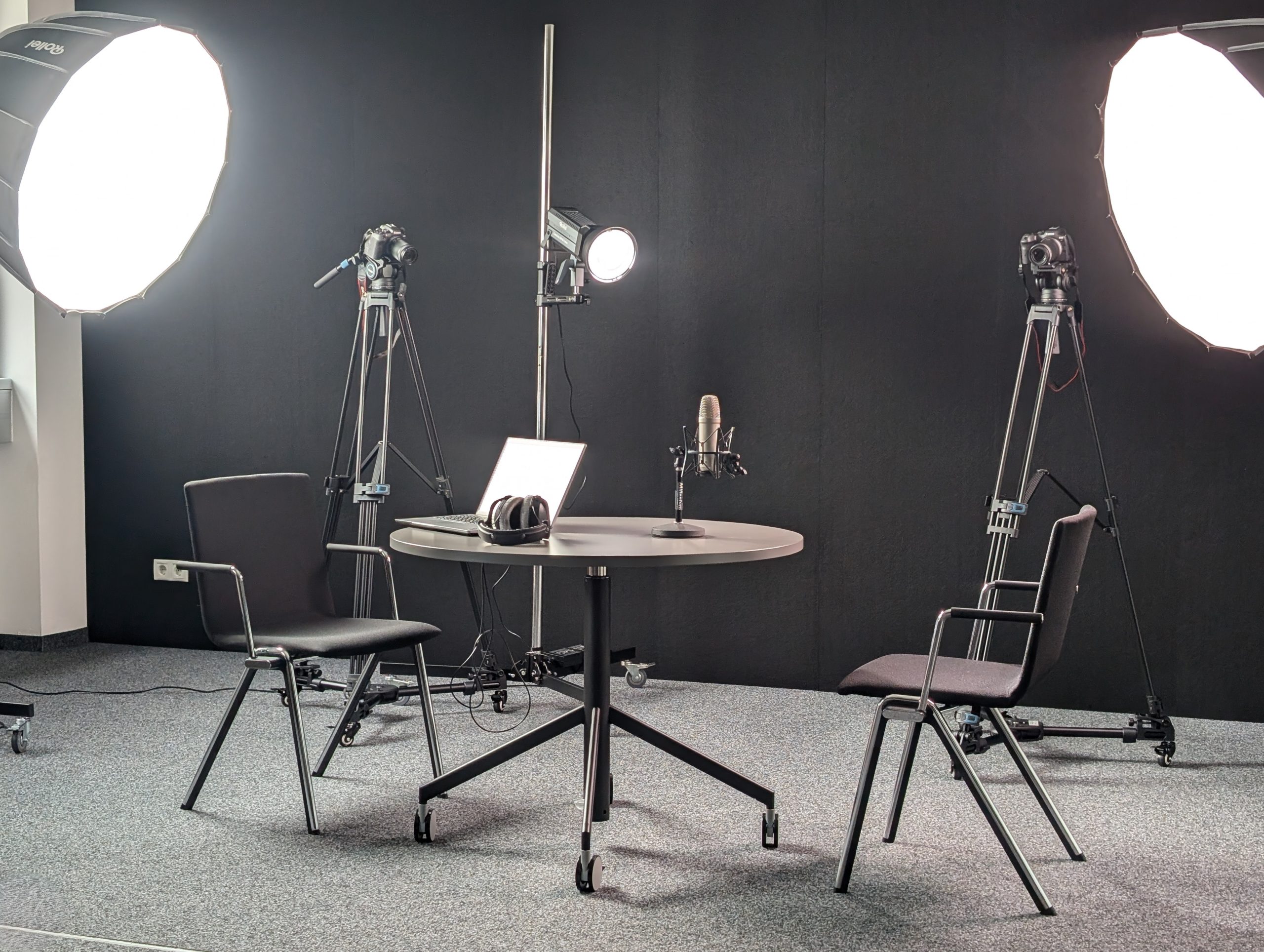 Der Lehrbeauftragte Christof Sumereder steht vor einem großen interaktiven Smart Lightboard und berührt den Bildschirm, auf dem bunte Grafiken und Daten zu sehen sind - zeigt das Smart Lightboard des Learning Design Lab in praktischer Anwendung.