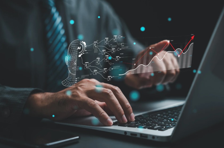 Hände tippen auf Laptop-Tastatur, darüber schweben holografische Visualisierungen eines digitalen Kopfes, Netzwerkdiagramme und Wachstumskurven mit türkisen Lichtpunkten - symbolisiert die KI-gestützte Analyse und Auswertung von Studierendenarbeiten mit Tools wie Claude und NotebookLM in der Hochschullehre.